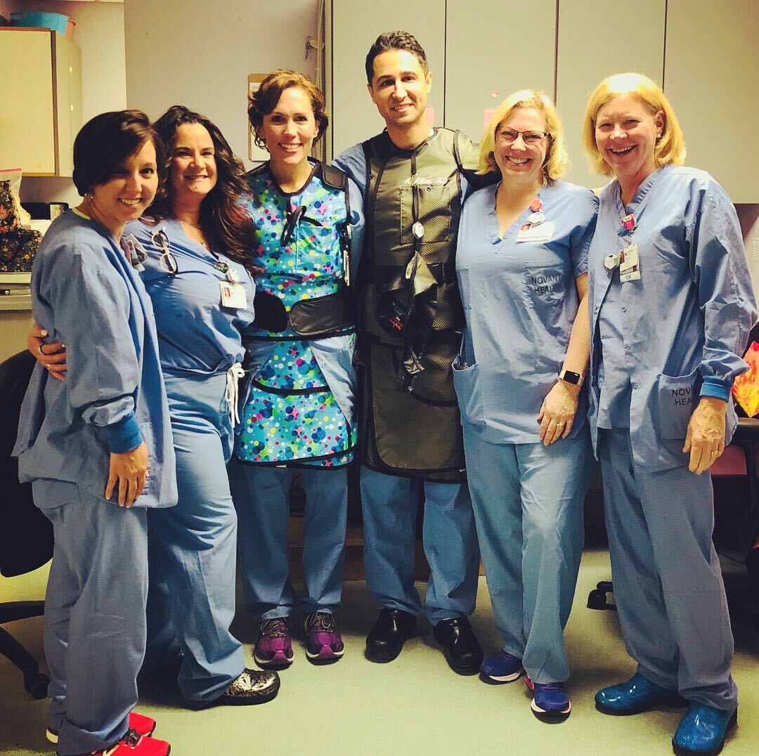 Dr. Allaei in lead apron with cath lab nurses and technologists after a case